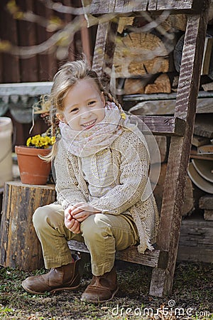 Cute blonde child girl having fun in early spring garden Stock Photo