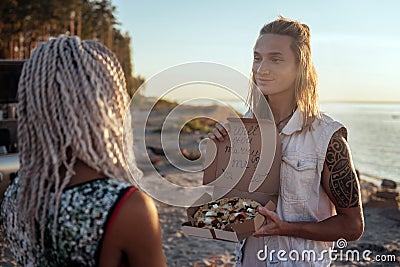 Cute blonde-haired man making very extraordinary proposal his woman Stock Photo