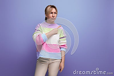 cute blondie woman showing copy space aside on purple background Stock Photo