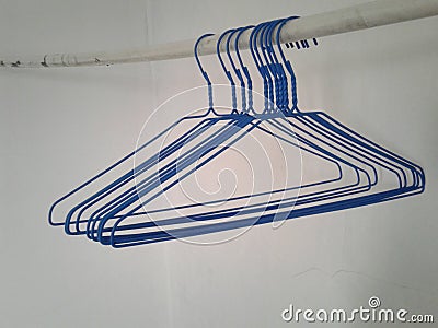Cute blue hangers hangin on a white pipe Stock Photo