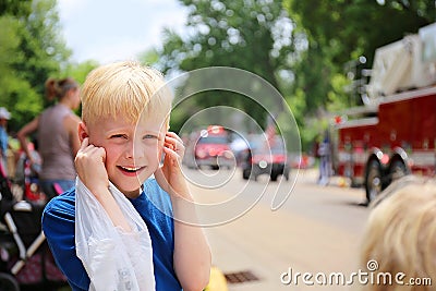 Cute Boy Child at Parade Plugging his Ears from the Loud Fire Truck Sirens Stock Photo