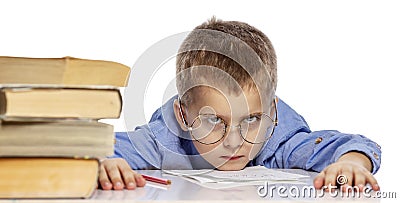 Cute boy in glasses of school age is tired of learning. I hung my head on textbooks. Close-up. Isolated on a white background Stock Photo