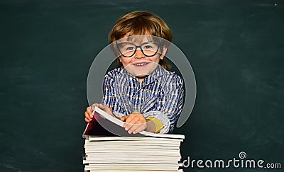 Cute boy with happy face expression near desk with school supplies. First school day. Schoolkid or preschooler learn Stock Photo