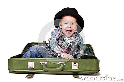 Cute boy in a hat sitting in a suitcase Stock Photo