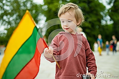 Cute boy holding tricolor Lithuanian flag on Lithuanian Statehood Day, Vilnius, Lithuania Stock Photo