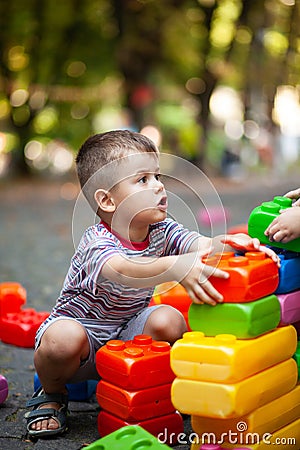 Cute boy playing with buiding toy colorful blocks. Kid with happy face playing with plastic bricks. Plastic Large Toy Stock Photo