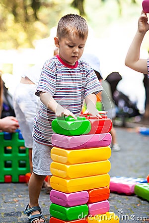 Cute boy playing with buiding toy colorful blocks. Kid with happy face playing with plastic bricks. Plastic Large Toy Stock Photo