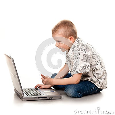 Cute boy playing with laptop Stock Photo