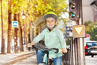 Cute boy riding his bike on green signal of lights Stock Photo