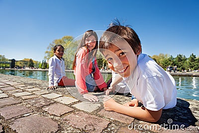 Cute boy sitting on the embankment with friends Stock Photo