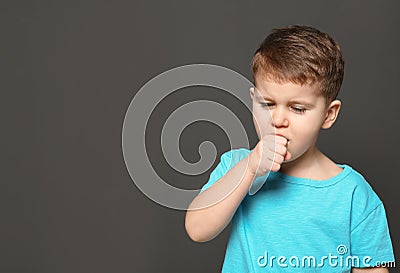 Cute boy suffering from cough on dark background Stock Photo