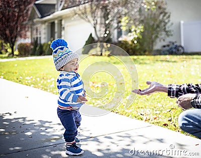 Cute boy walking on a sidewalk reaching for a free handout Stock Photo