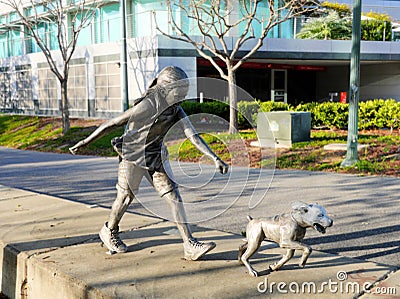 Cute bronze statue of girl playing with her dog Stock Photo