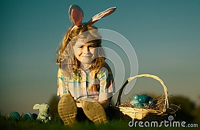 Cute bunny child boy with rabbit ears. Children hunting easter eggs on sky background with copy space. Child with easter Stock Photo