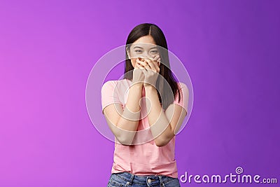 Cute carefree happy young asian girlfriend fooling around, giggle, close mouth palms not laugh loud, acting silly Stock Photo