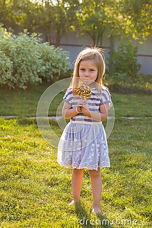 Cute cauasian baby girl and big lollipop Stock Photo