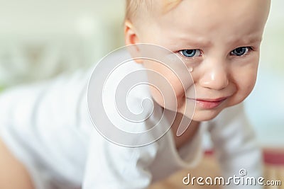 Cute caucasian blond toddler boy portrait crying at home during hysterics. Little child feeling sad. Little actor acting sadness Stock Photo