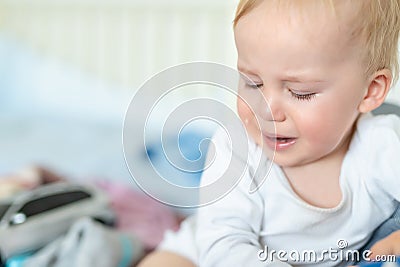 Cute caucasian blond toddler boy portrait crying at home during hysterics. Little child feeling sad. Little actor acting sadness Stock Photo