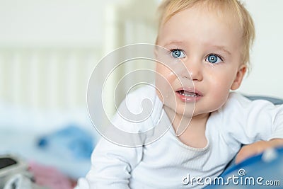 Cute caucasian blond toddler boy portrait crying at home during hysterics. Little child feeling sad. Small pensive baby after Stock Photo