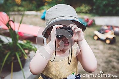 Cute Caucasian girl in yellow dress and hat looking through binoculars Stock Photo