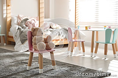 Cute chair with bunny ears and teddy bear in children`s bedroom Stock Photo