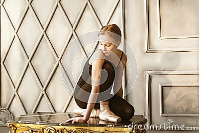 a cute charming young ballerina in a warm-up bodysuit posing in a loft Stock Photo