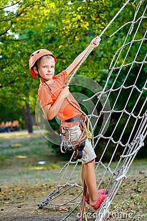 Cute child, boy, climbing in a rope playground Stock Photo