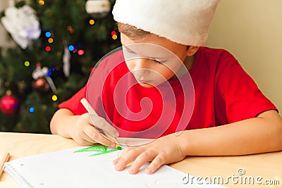 Cute child boy write letter to Santa, Christmas tree on background Stock Photo