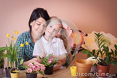 Cute child girl helps her mother to care for plants Stock Photo