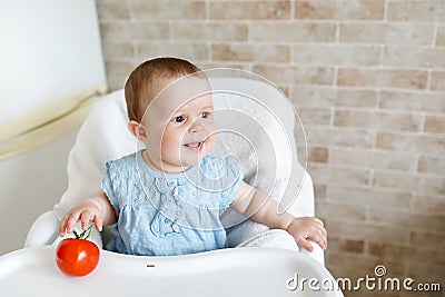 Cute child little girl eating healthy food in kindergarten. baby in chair Stock Photo