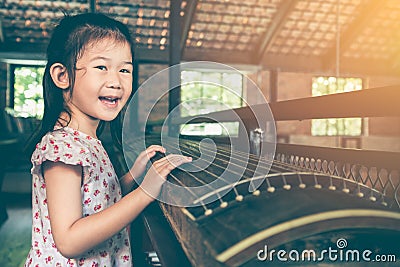 Cute child playing stringed instruments and having fun. Stock Photo