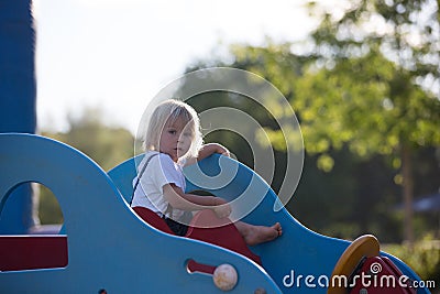 Cute child, toddler boy, playing on the playgroung on cute car Stock Photo