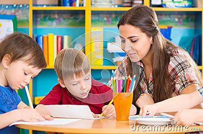 Cute children drawing with teacher at preschool class Stock Photo