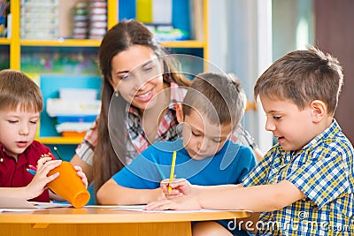 Cute children drawing with teacher at preschool class Stock Photo