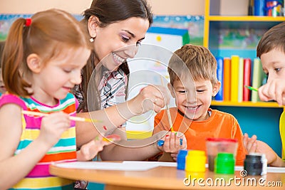 Cute children drawing with teacher at preschool class Stock Photo