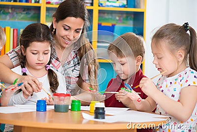 Cute children drawing with teacher at preschool class Stock Photo