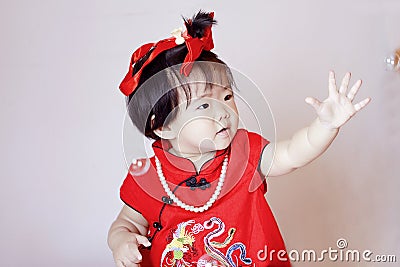 Cute Chinese little baby in red cheongsam play soap bubbles Stock Photo