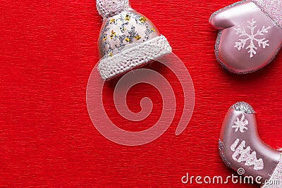 Cute Christmas tree decoration ornaments in shape of hat mittens sock mitten on red textured wrapping paper background. New Years Stock Photo