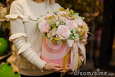 Cute composition of fresh pink flowers in round box in hands of woman. Stock Photo