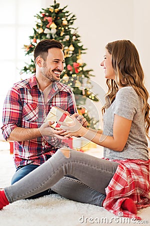 Cute couple exchanging Christmas presents on Christmas morning Stock Photo