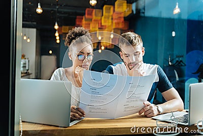 Cute couple feeling curious while choosing some desserts Stock Photo
