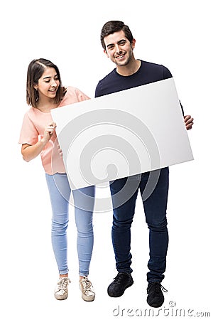 Cute couple holding a white sign Stock Photo