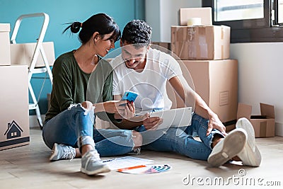 Cute couple looking ideas to decorate the new apartmentin in the smart phone sitting on the floor Stock Photo