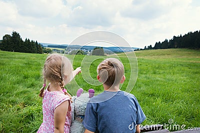 Cute couple sitting on bench with view on mountains Stock Photo