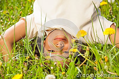 Cute curly boy stands upside down in field Stock Photo