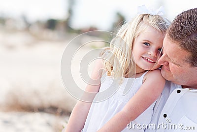 Cute Daughter Cuddles up with Her at the Beach Stock Photo