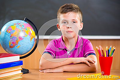 Cute diligent boy sitting in classroom Stock Photo