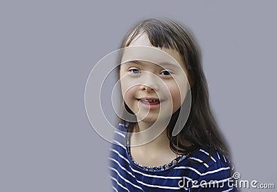 Cute down syndrome girl on the grey background. Stock Photo