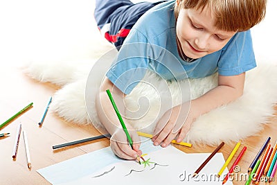 Cute dreaming child lies and draw Stock Photo