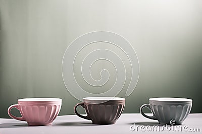 Cute empty ceramic coffee cups pastel colors on grey background Stock Photo